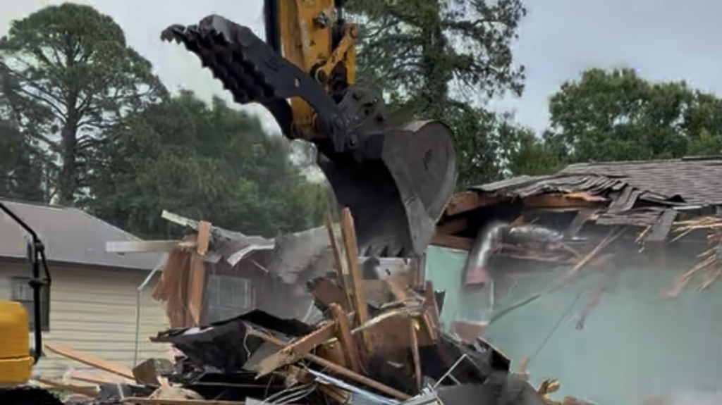 Excavator grapple tearing into a house during demolition in Fort Walton Beach, FL